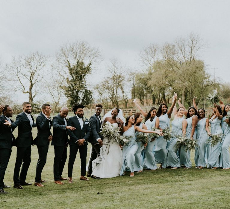 Bridal party in blue bridesmaid dresses with groomsmen