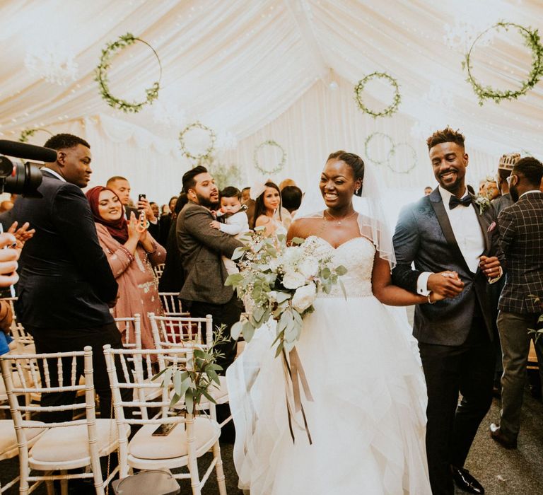 Bride in strapless bride dress with Spring flower bouquet with wooden wedding signs and hoop decor