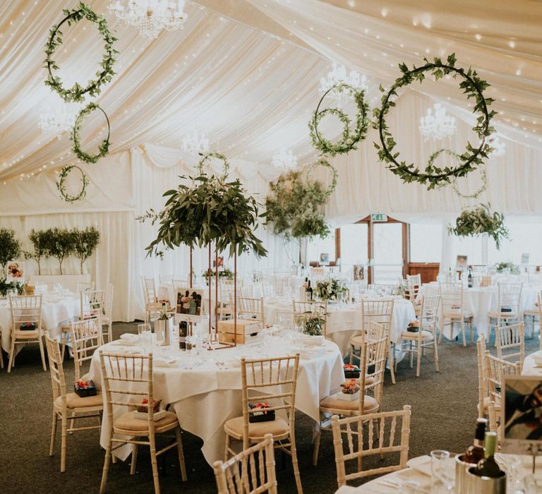 Marquee wedding reception with wooden wedding signs and hoop decor