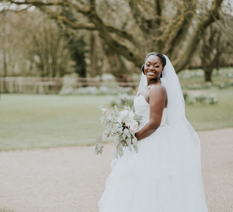 Bride wearing strapless wedding dress with veil at Crockwell Farm