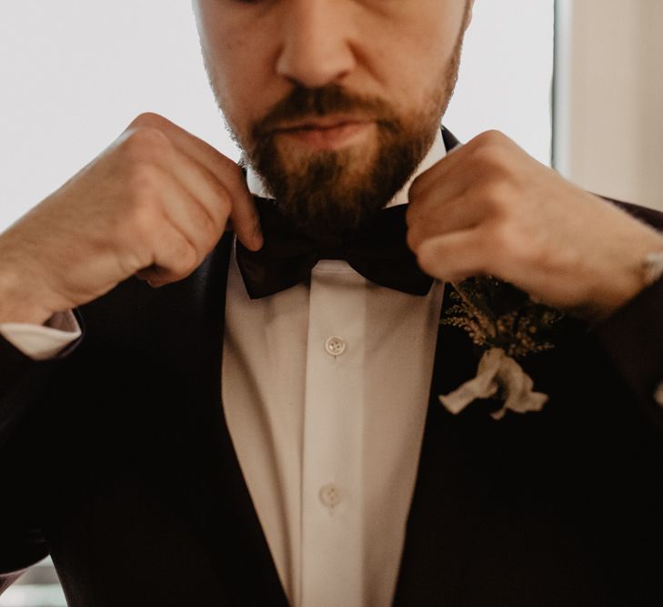 Groom in brown wedding suit with bow tie