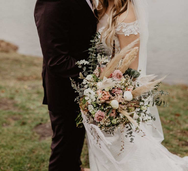 Brown wedding suit for groom with bride in boho wedding dress