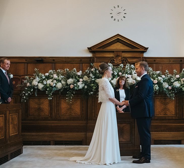 Bride and groom exchanging vows at town hall wedding