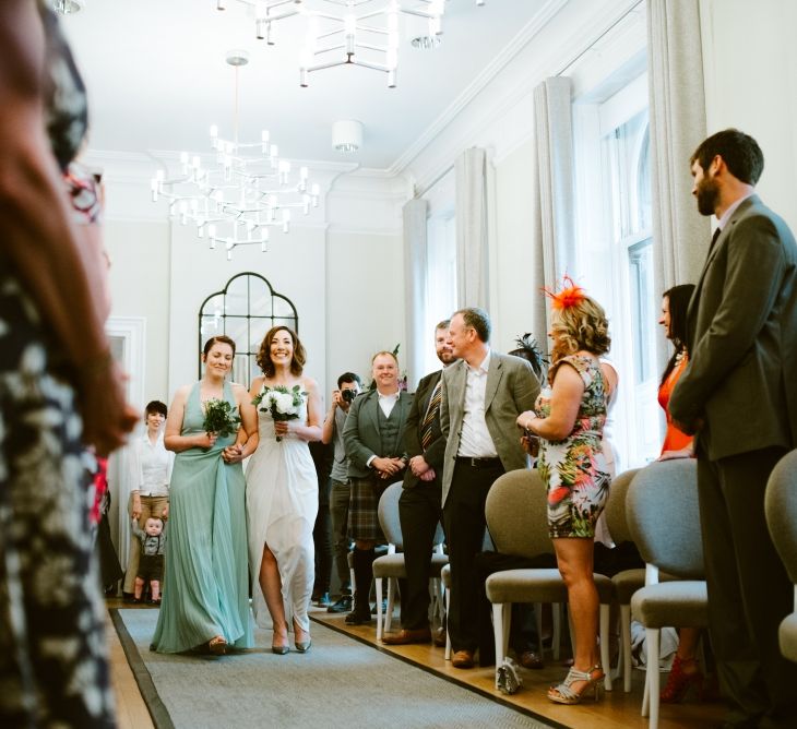 Bride walking down the aisle with bridesmaid