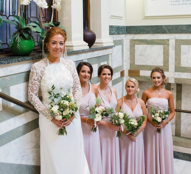 Bride and bridesmaids lining the stairs