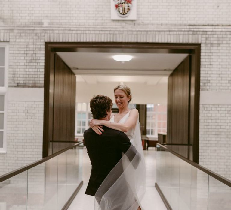 Groom picking up his bride at registry office wedding