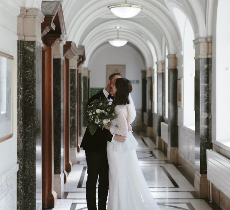 Bride and groom kissing in the registry office halls