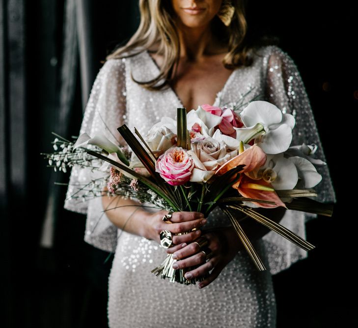 contemporary bouquet with gold sprayed palms, roses, orchids and anthuriums