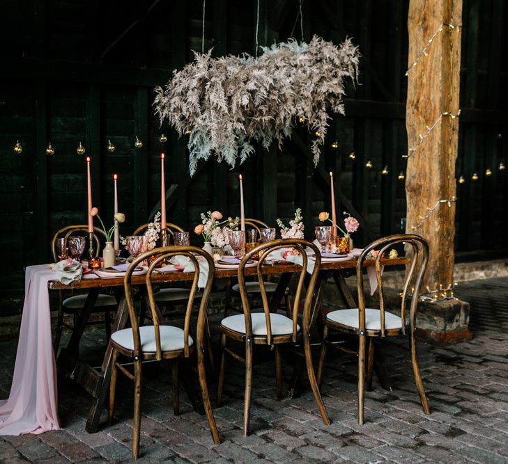 Wooden Table Setting with Flower Cloud Installation and Coloured Table Ware and Flower Decor