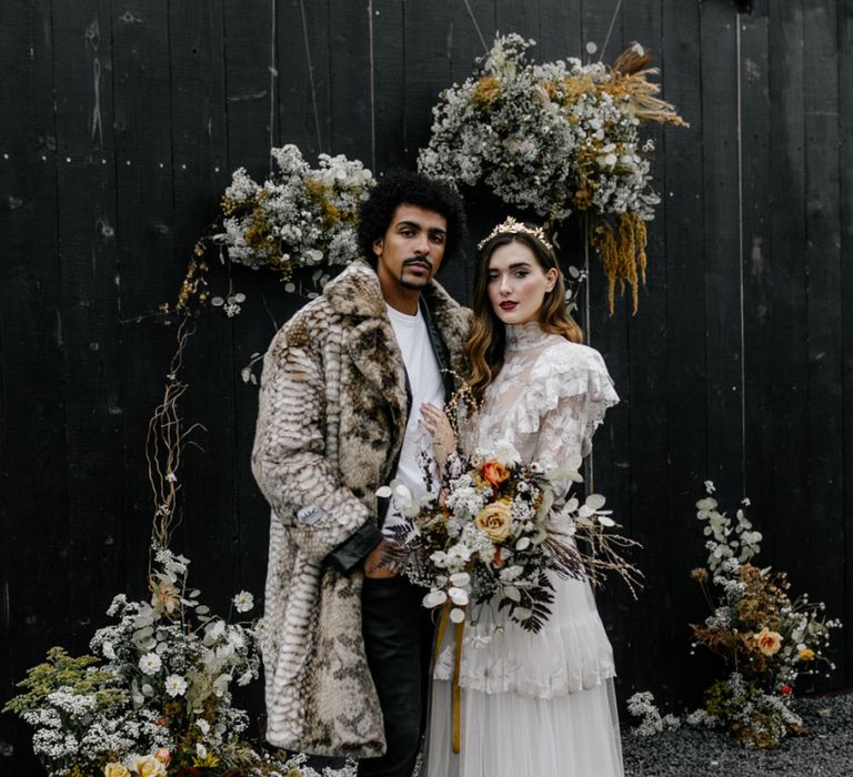 Bride in Tired Wedding Dress with Dried Flower Bouquet and Groom in Faux Fur Coat