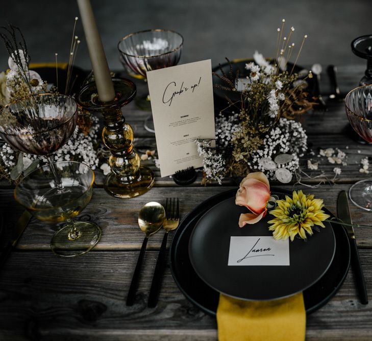 Place Setting with Black Table Ware, Yellow Napkin, Individual Flowers Stems and Modern Name Place Card