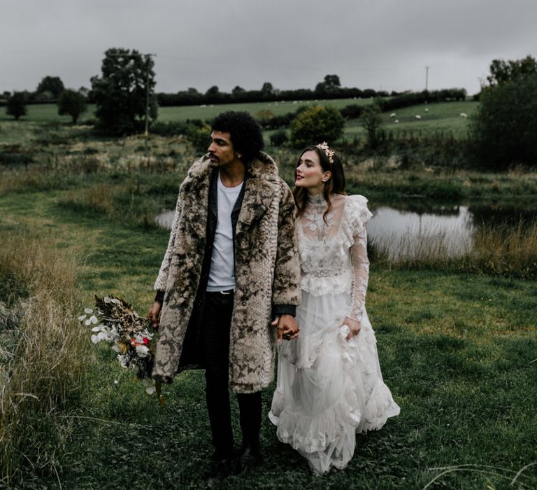 Stylish Bride in Lace KATYA KATYA Wedding Dress with High Neck Detail and Groom in Faux Fur Coat