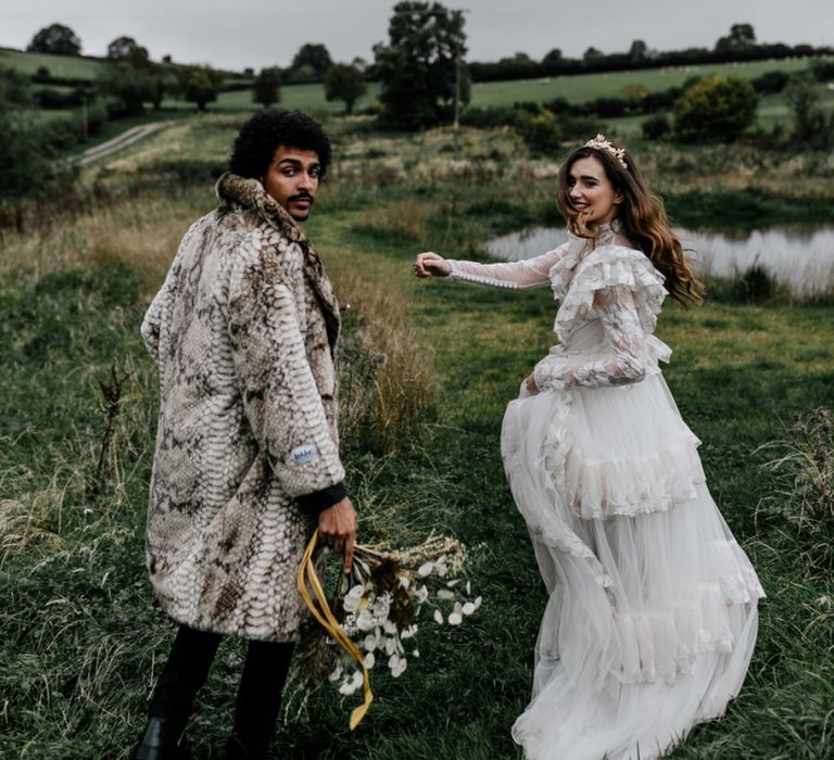 Stylish Bride in Wedding Dress with Long Sleeves and Gold Crown and Groom in Faux Fur Coat