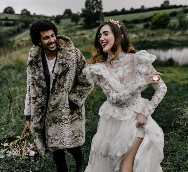 Bride in High Neck Wedding Dress and Long Sleeves and Groom in Faux Fur Overcoat