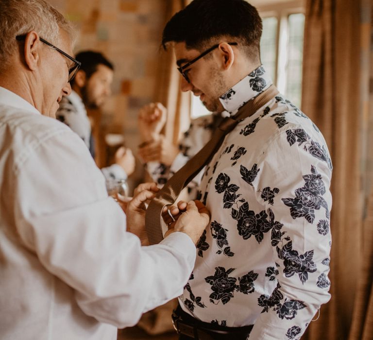 Groom getting ready in patterned shirt