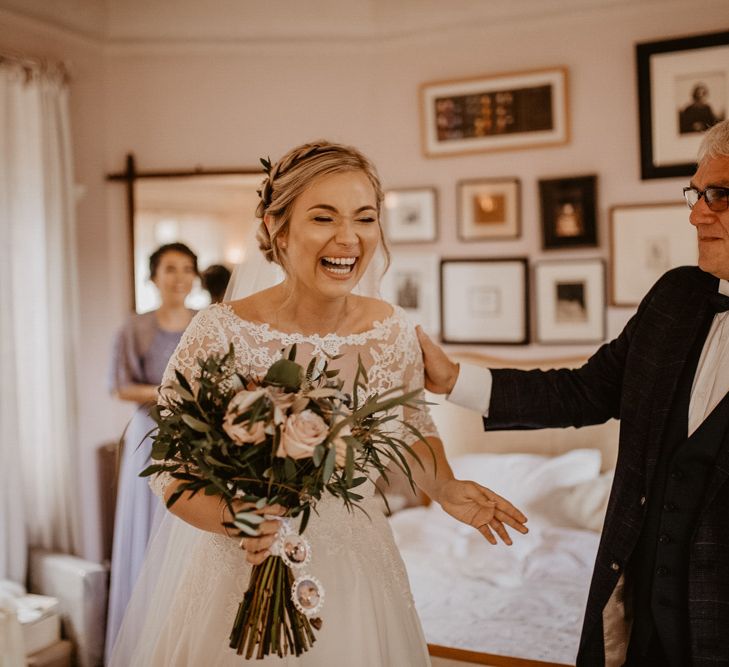 Father of the bride and daughter laughing on wedding morning