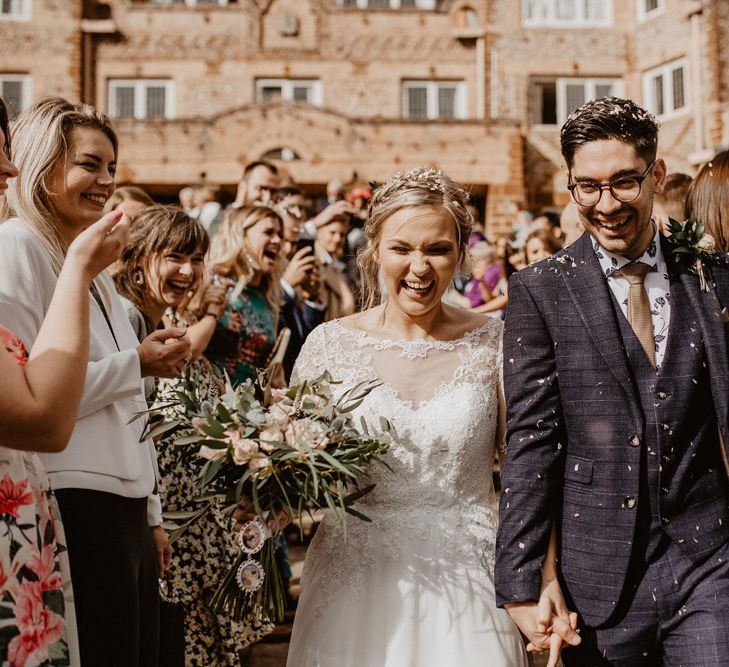 Confetti moment at Voewood with bride in lace wedding and groom in navy suit