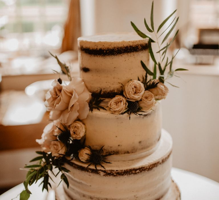 Semi naked wedding cake on rustic tree stump cake stand