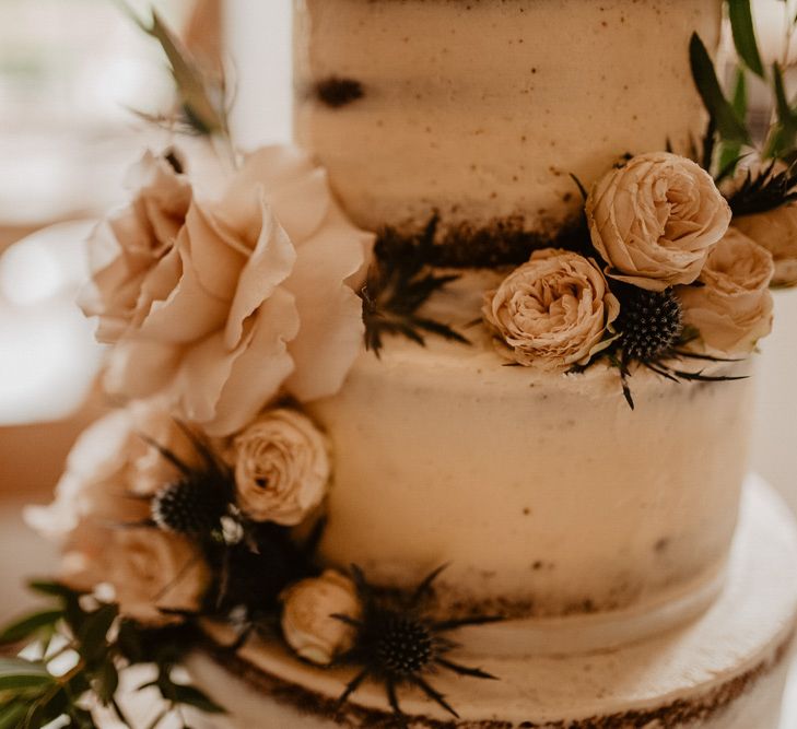 Pink wedding flowers decorating the rustic wedding cake