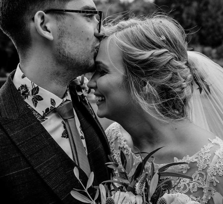 Portrait of the groom kissing his bride head by Camilla Andrea Photography