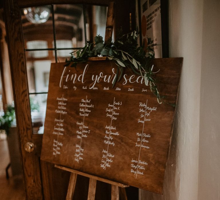 Wooden seating chart and menu sign at Voewood wedding