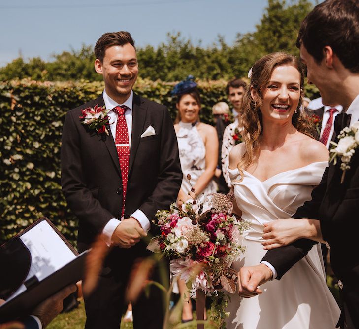 Outdoor Wedding Ceremony with Brother Giving Away His Sister in a Satin Bardot Wedding Dress