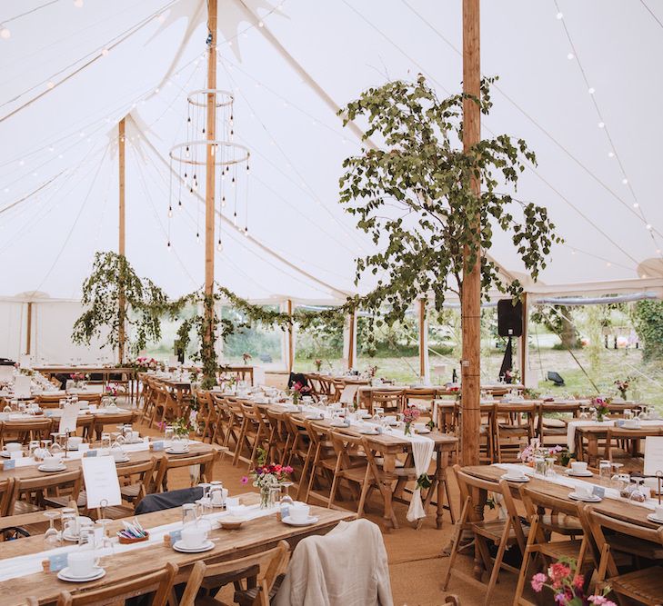 Rustic Tent Wedding Decor with Wooden Tables, Greenery and Festoon Lights