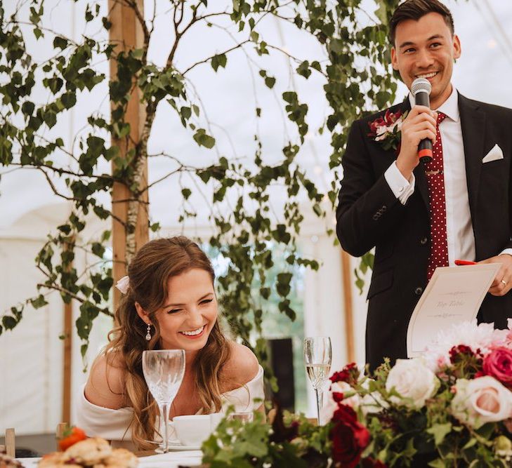 Groom in Black Moss Bros. Suit with Burgundy Tie Giving His Wedding Speech