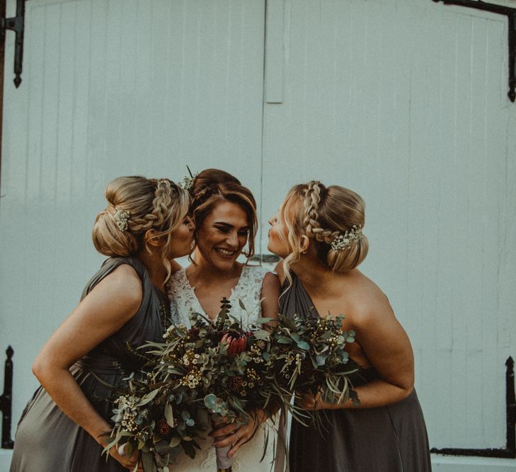 Bride in The Eleni Wed2B Lace Wedding Dress and Bridesmaids in Sage Green One Shoulder Dresses