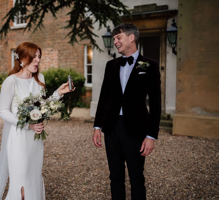 Bride and groom sipping from a hip glass