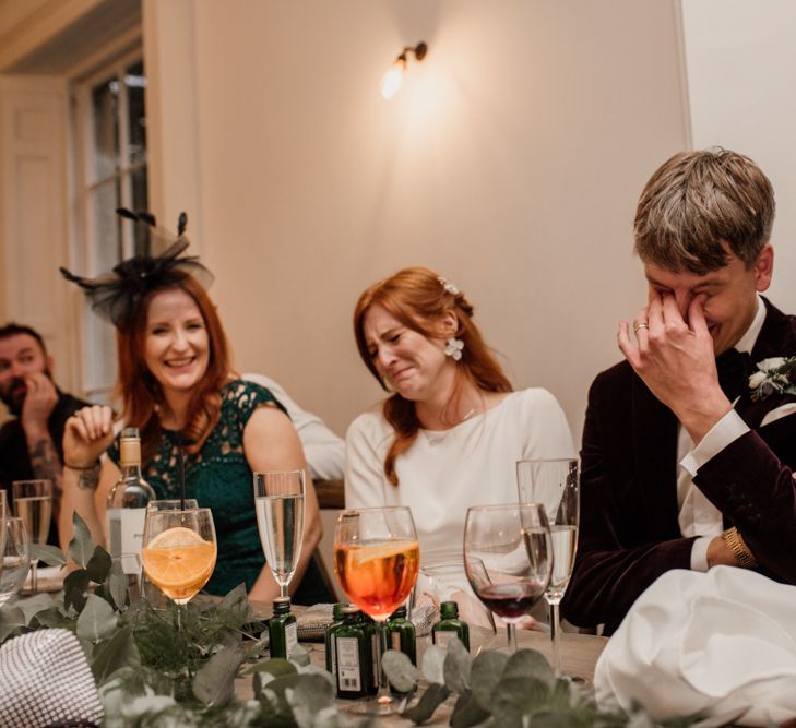 Bride and groom laughing during wedding speeches