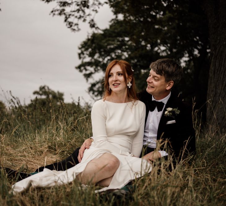 Bride and groom portrait in a field by Magda K Photography