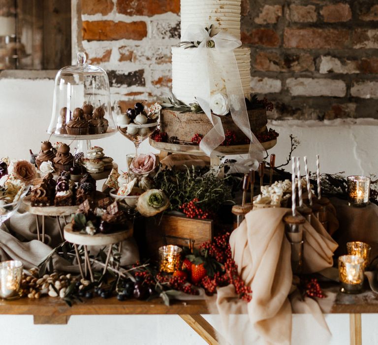 Dessert Table Loaded with Treats and Two Tier Wedding Cake