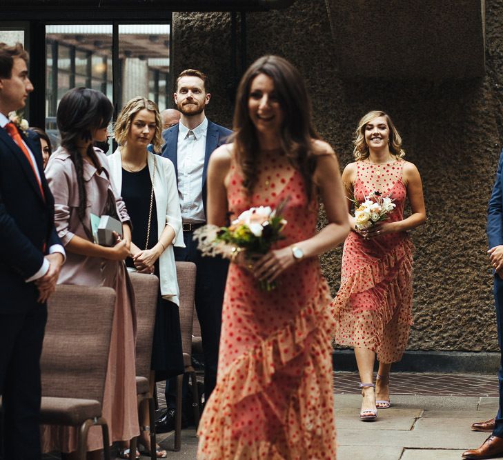 Bridesmaids in Sheer Orange Polka Dot Dresses Walking Down the Aisle