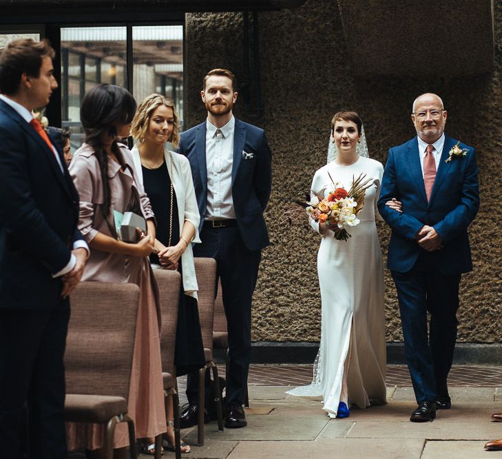 Wedding Ceremony Bridal Entrance in Charlie Brear Dress with Long Sleeves and Front Split