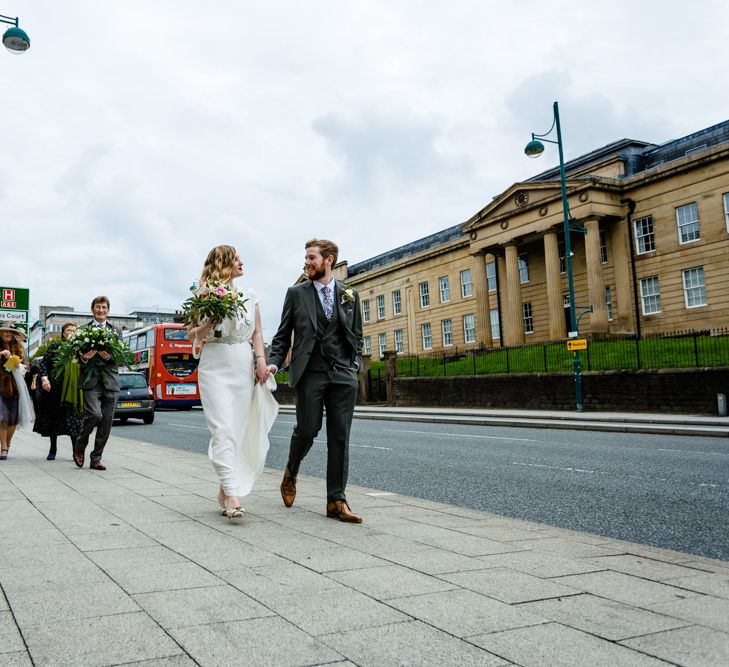 Bride in Vintage Wedding Dress and Groom in Tailored Suit  Walking Through Manchester