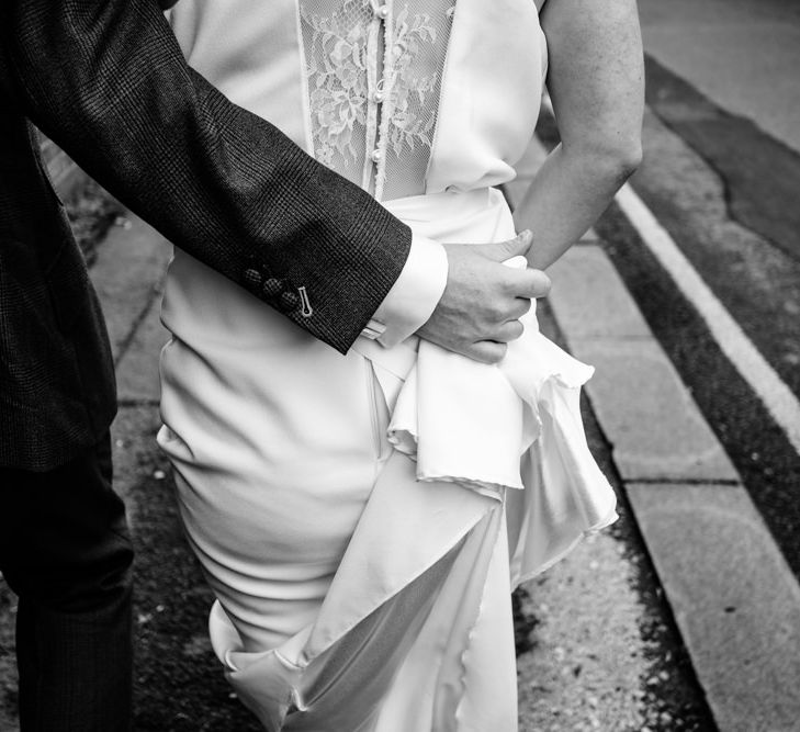 Groom Holding Brides Wedding Dress Train Up