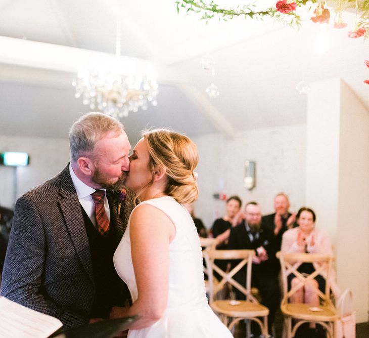 Bride and groom kiss at altar