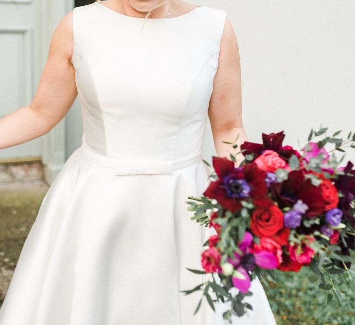 Tea-length wedding dress with jewel coloured bouquet