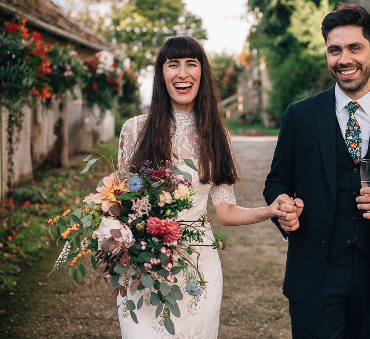 Bride in Catherine Deane Wedding Dress with Wild Flower Bouquet and Groom in Paul Smith Suit and Floral Liberty Print Tie