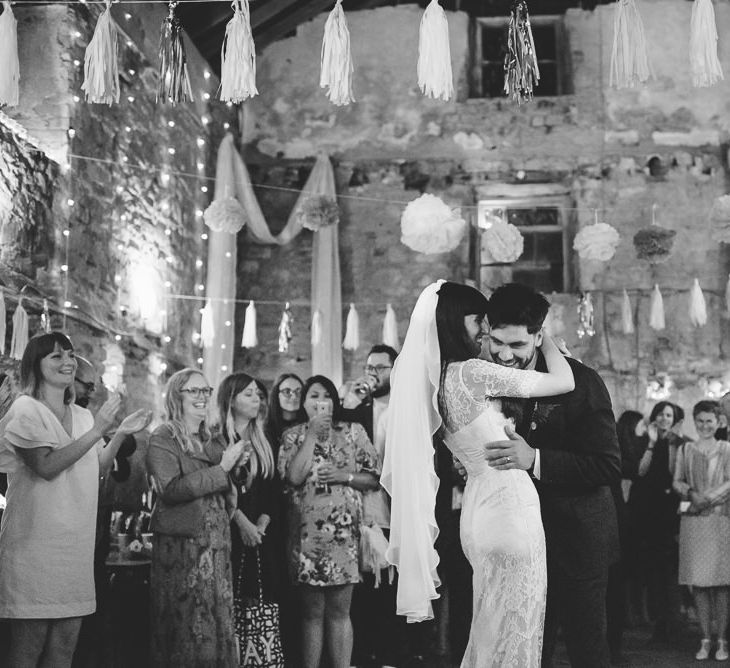 Bride and Groom Enjoying First Dance with Tissue Tassels and Pom Pom Ceiling Decor