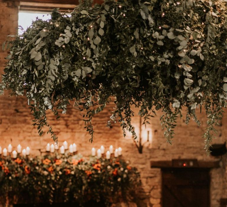 Intimate candle lit wedding reception at Cripps Barn with foliage chandelier