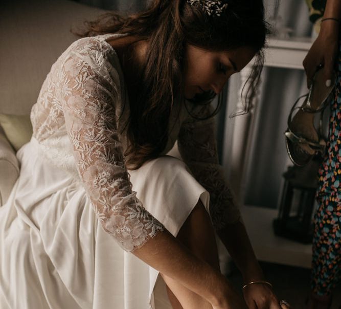 Bride in Donatelle Godart Wedding Dress Putting on Chloé Bridal Shoes