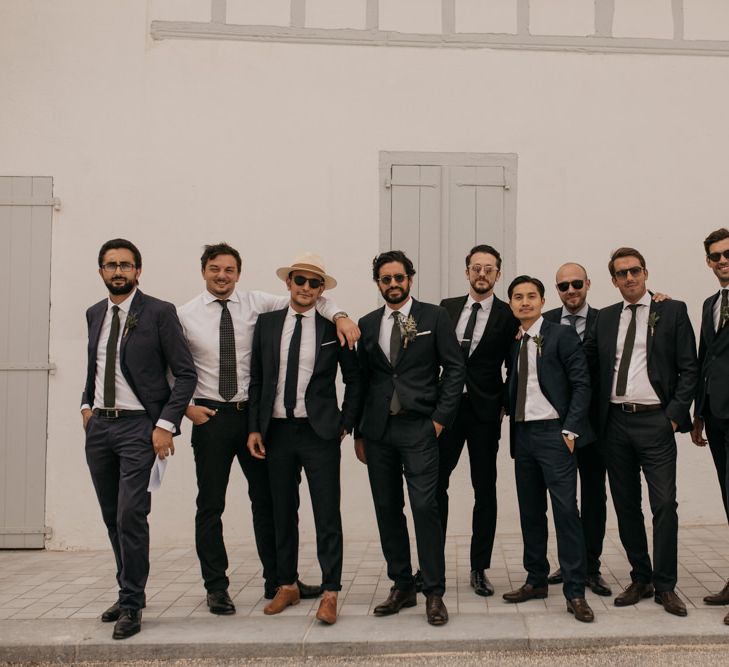 Stylish Groom in Black De Fursac Suit with Groomsmen