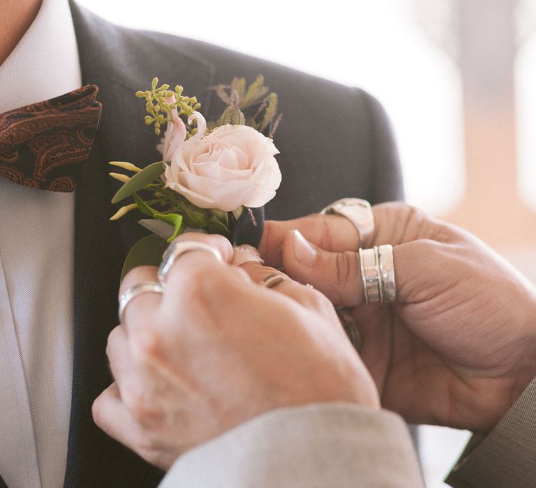 Blush rose buttonhole for groom in bowtie