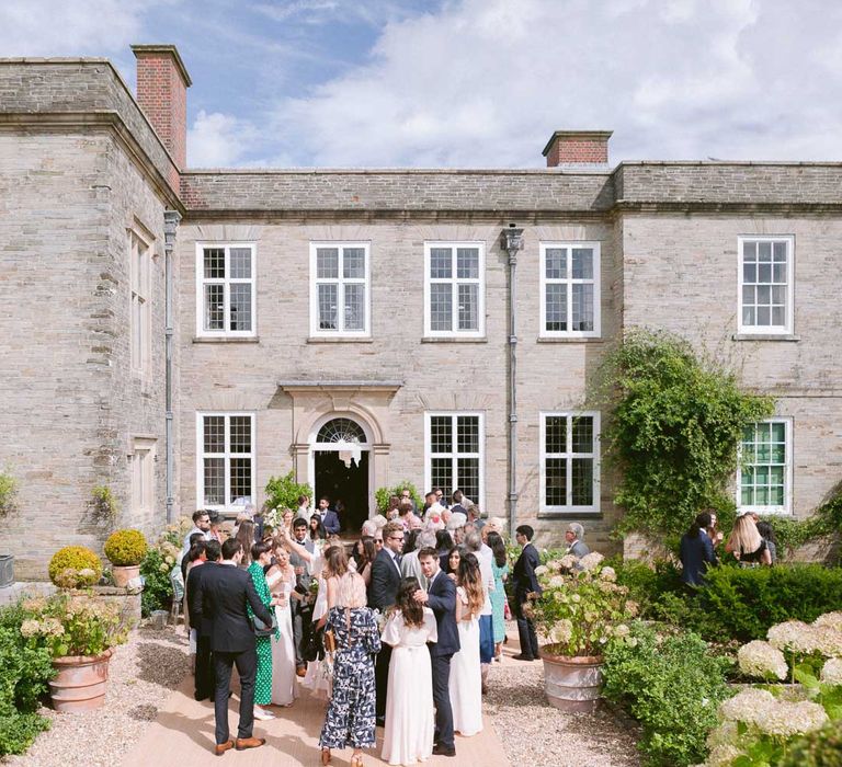 Guests enjoy a drink out Shilstone House wedding venue in Devon