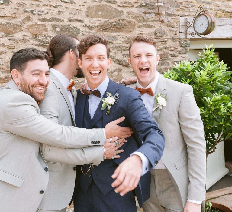 Groomsmen wear light suits with matching bowties