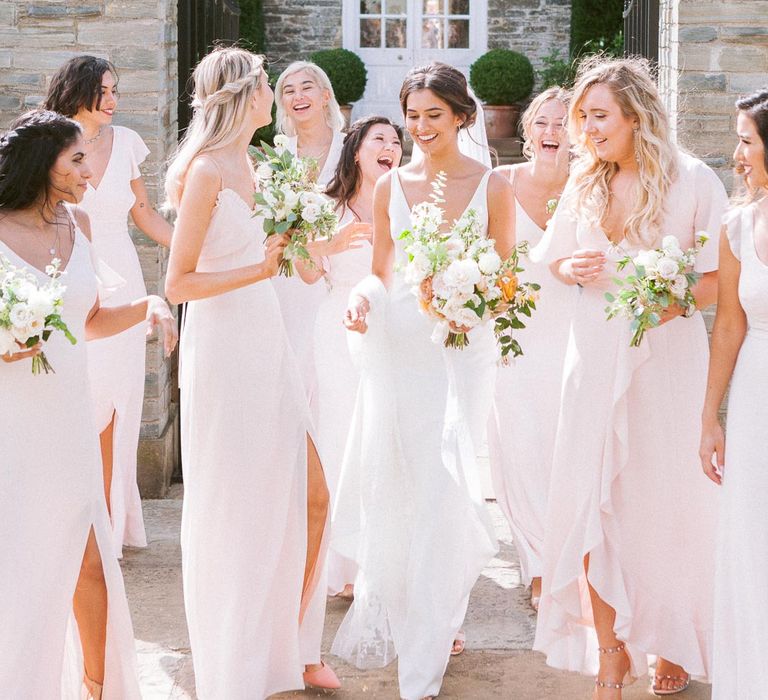 Bridesmaids in pink dresses with bride in simple wedding dress