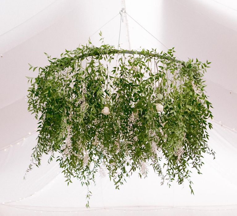 Foliage chandelier hanging above dinner reception