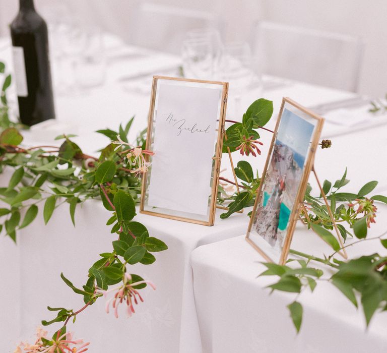 Wedding table decor with foliage and photo frames